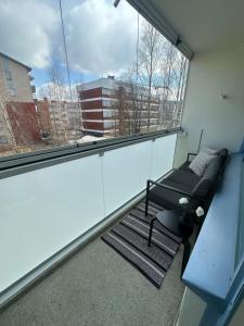 a balcony with a bench and a large window at Arctic City Apartment in Rovaniemi