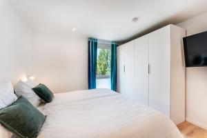 - une chambre avec un grand lit blanc et des oreillers verts dans l'établissement Luxuswohnung Traumblick - Neubau 2023, à Schluchsee