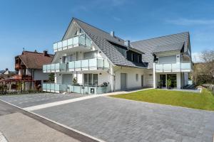 uma grande casa branca com uma entrada em Luxuswohnung Traumblick - Neubau 2023 em Schluchsee
