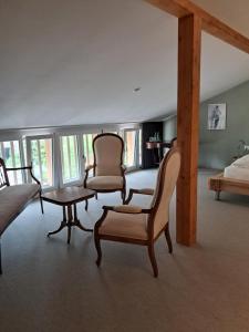 sala de estar con sillas, mesa y cama en Hotel Restaurant Croix Blanche, en Sugiez