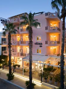 尼欧波洛伊Eliza Hotel by Panel Hospitality的前面有棕榈树的酒店