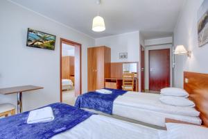 Habitación de hotel con 2 camas y escritorio en Marina en Ostrowo