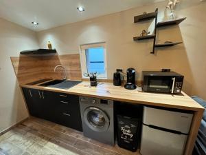 a kitchen with a sink and a washing machine at MAZET en CAMPAGNE in Arles +3 photos