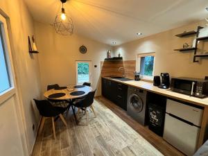 a kitchen with a table and a sink and a washer at MAZET en CAMPAGNE in Arles