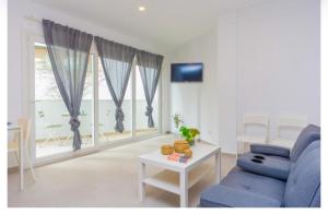 a living room with a blue couch and a window at Hugo 1 in Cala Ratjada