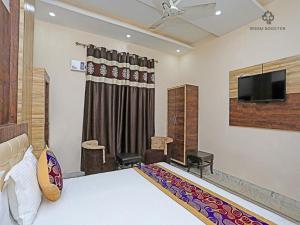 a bedroom with a bed and a flat screen tv at HOTEL KRISHNA RESIDENCY in Amritsar