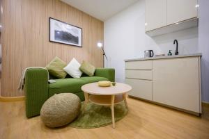 a living room with a green couch and a table at 2 Bed 2 Bath / Luxury / 1 min walk to BTS Asok in Bangkok