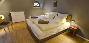 una camera da letto con un letto grande con lenzuola bianche di Lieblingsplatz a Grömitz Altre 5 foto