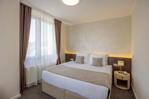 a hotel room with a large bed and a window at Nobel West Hotel in Belgrade