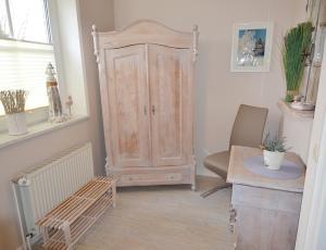 een kamer met een kast, een tafel en een stoel bij Teichhaus - 6033 in Grömitz