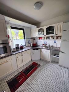 a kitchen with white cabinets and a red rug on the floor at Landgang in Wittdün
