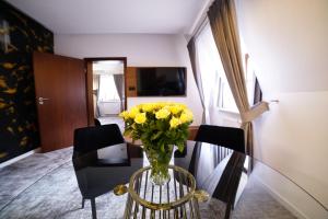 a vase of yellow flowers sitting on a glass table at Hotel Korona Spa & Wellness in Lublin