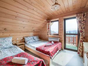 um quarto com 2 camas num chalé de madeira em Domek w Pieninach em Grywałd