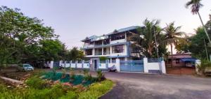 a house with a blue fence in front of a street at Captains Cabin backwater resort in Alleppey