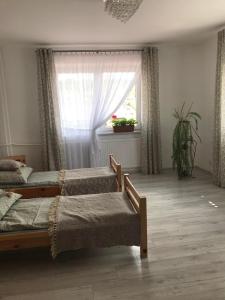 1 dormitorio con 3 camas y ventana en Agroturystyka Pod Dzwonnicą en Zubrzyca Dolna