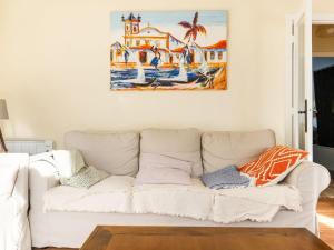 a white couch in a living room with a painting on the wall at Belvilla by OYO Casa Porto do Son in Porto do Son