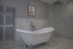 a white bath tub in a white bathroom at Oak Lodge in Burley +40 photos