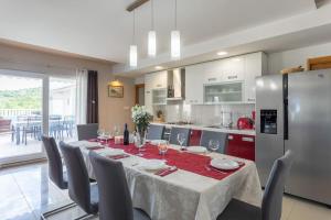 a dining room with a table and a kitchen at Ferienhaus - Villa Delic - Makarska Exklusiv in Kreševo +21 photos