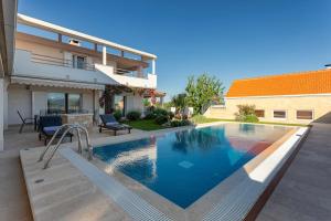 a swimming pool in front of a house at Ferienhaus - Villa Delic - Makarska Exklusiv in Kreševo