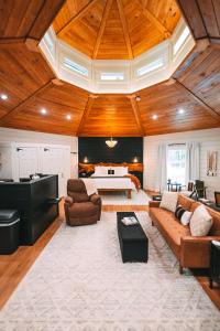 a large living room with a couch and a piano at Romantic Gazebo Cottage w Hot Tub & Pond in Marshallville