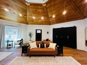 a living room with a couch and a table at Romantic Gazebo Cottage w Hot Tub & Pond in Marshallville
