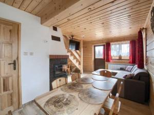 a living room with a table and a fireplace at Nowy domek w Pieninach in Grywałd