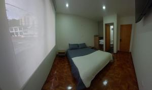 - une chambre avec un lit blanc dans l'établissement Casa Palermo Manizales, à Manizales