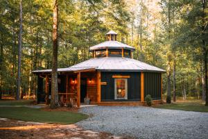 a cabin in the woods with a tower on top at Romantic Gazebo Cottage w Hot Tub & Pond in Marshallville