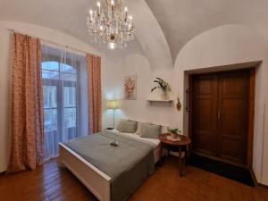 a bedroom with a large bed and a chandelier at Eliza Old Town Apartment in Košice