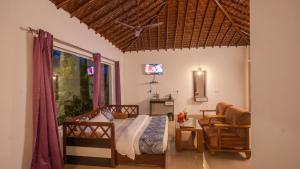 1 dormitorio con 1 cama, 1 silla y 1 ventana en Corbett Fun Resort en Rāmnagar