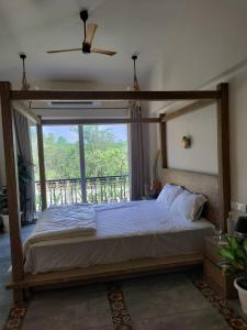 een slaapkamer met een hemelbed en een balkon bij Dezire Holidays South Goa in Goa