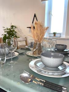 a table with plates and bowls and glasses on it at Forsyth Court Apartment - Two bedroom in Dagenham
