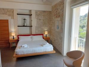 1 dormitorio con 1 cama con 2 sillas y una ventana en Itria Palace en Ragusa