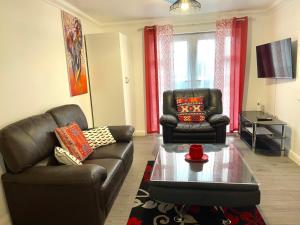 a living room with two leather chairs and a coffee table at The Grand Forsyth Apartment - Two bedroom in Dagenham