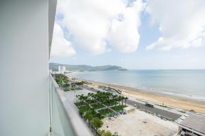 uma vista para a praia a partir da varanda de um edifício em TMS Luxury Residence Quy Nhơn em Quy Nhon