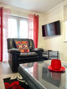 a living room with a leather couch and a table at Forsyth Court Apartment - Two bedroom in Dagenham