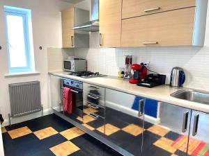 a kitchen with stainless steel cabinets and a sink at Forsyth Court Apartment - Two bedroom in Dagenham