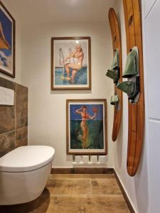 a bathroom with a toilet and pictures on the wall at Appartement 2 Pièces proche mer calme dans villa in Antibes