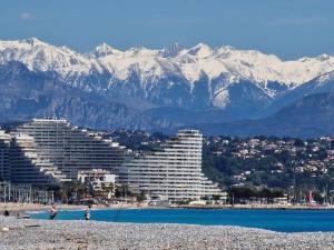 a view of a resort with snow covered mountains at Appartement 2 Pièces proche mer calme dans villa in Antibes