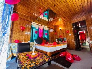 a room with a bed and a couch and red balloons at Hotel Hamta View Manali !! Top Rated & Most Awarded Property in Manali !! in Manāli