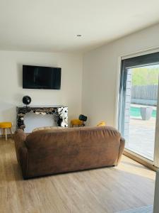 a brown couch in a living room with a fireplace at le chant de la rivière in Abbeville +29 photos