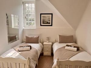 een slaapkamer met 2 bedden en een raam bij The Manor House in Sir Lowry Pass