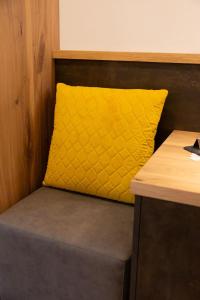 a yellow pillow sitting on top of a bench at Hotel Christin in Ora/Auer