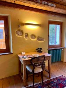 een kamer met een houten bureau met een stoel en ramen bij Romeos Cottage Public free parking 2 bedrooms in Verona