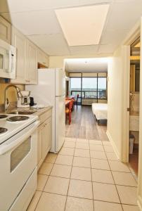 a kitchen with a white refrigerator and a living room at Holiday Sands South in Myrtle Beach