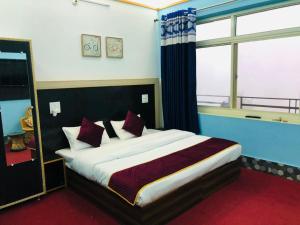 a bedroom with a large bed with a mirror at Goroomgo Hotel Paradise Inn Dharamshala With Luxury Mountain View Room and parking - Best Hotel in Dharamshala in Dharamshala