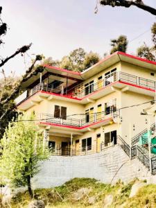 a house on the side of a hill at Goroomgo Hotel Paradise Inn Dharamshala With Luxury Mountain View Room and parking - Best Hotel in Dharamshala in Dharamshala