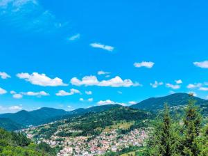 a view of a town in the mountains at Хотел Кючуковата Къща in Banite