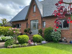 uma casa de tijolos com um jardim de flores em Wohlfühlen mitten in Wacken em Wacken