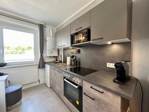 una cocina con electrodomésticos de acero inoxidable y una ventana en StayRoom Apartments I "U151", en Linz